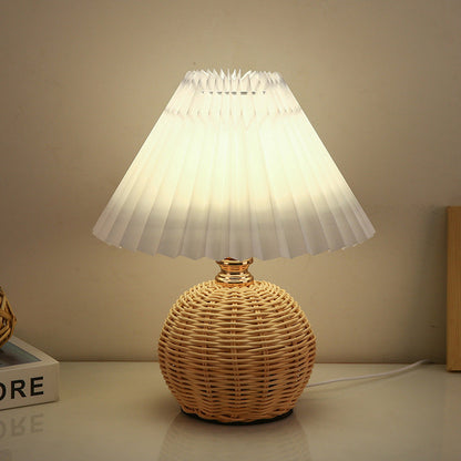 Rattan-Tischleuchte mit geplissiertem Lampenschirm